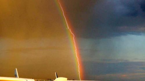 photo of Amazing photo shows lightning striking an airliner flying in a rainbow image