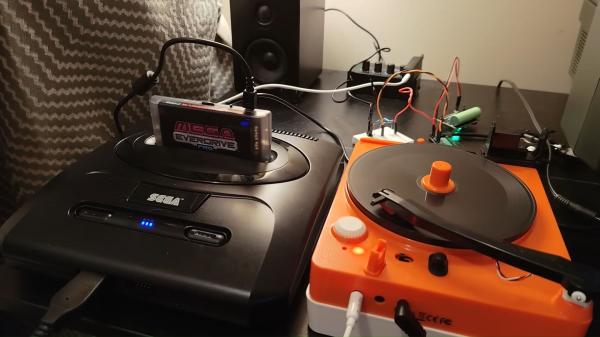 photo of Retro gaming enthusiast attempts loading games to Sega Genesis from a vinyl record player, recording game data as sound… image